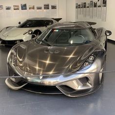 two silver sports cars parked in a showroom