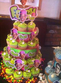 a cake with cupcakes and pictures on the top is surrounded by candies