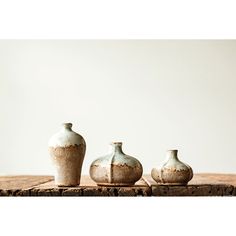 three vases sitting on top of a wooden table