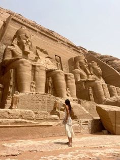 a woman standing in front of an egyptian temple