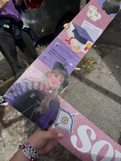 a person holding up a pink snowboard with pictures on it's bottom half