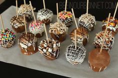 chocolate covered candies are lined up on a table with toothpicks in them