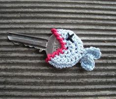 a crocheted keychain with a stuffed animal on it's side