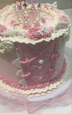 a pink and white cake with a crown on top