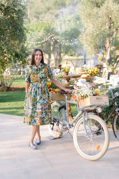 a woman standing next to a bike with flowers on it