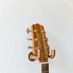 Display your guitar with rustic charm using our Copper Guitar Holder. Handcrafted from solid copper, this wall hanger not only securely holds your instrument but also adds an artisanal touch to your space. The unique design features a handmade copper guitar pick incorporated into the holder, showcasing the fusion of craftsmanship and functionality. Perfect for musicians who appreciate both style and practicality, this rustic accessory enhances the ambiance of any music room or studio. Materials: Rustic Guitar, Guitar Holder, Rustic Accessories, August Birthstone Jewelry, July Birthstone Jewelry, Guitar Accessories, Zodiac Jewelry, Gifts For New Mums, Jewelry Ring Box