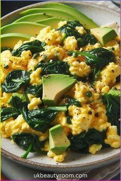 scrambled eggs with spinach and avocado on a plate