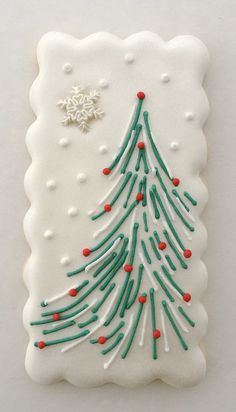 a decorated christmas tree cookie on a white surface