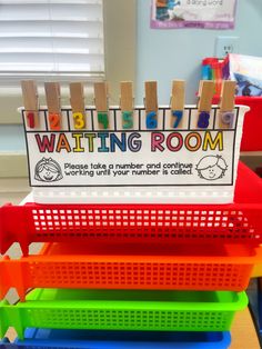 a stack of plastic bins with clothes pins on them and a sign that says waiting room