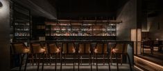 a dimly lit bar with chairs and shelves