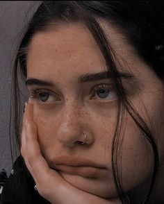 a woman with freckles on her face and nose is looking at the camera