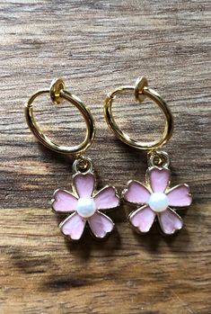 Cute dangling floral clip on earrings. Enamel on gold coloured with faux pearl/rhinestone centres pendants dangling from spring hoop closures.  Earrings are not intended to be worn while sleeping bathing or swimming. Not recommended for children under three.See more: https://www.etsy.com/ca/shop/CleverLittleEars CANADIAN PRICES INCLUDE GST/HST WHERE APPLICABLE. ETSY WILL CALCULATE ANY PST OWING AT CHECKOUT. While the cost of shipping makes returns or exchanges impractical, please do contact me w