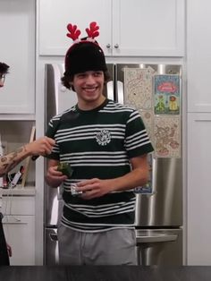 two people standing in a kitchen one is wearing a starbucks beanie