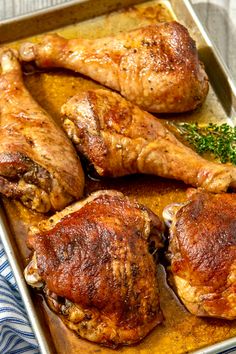 two chicken legs on a baking sheet with herbs