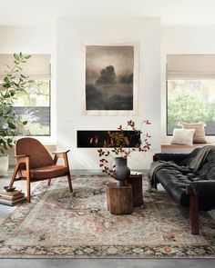 a living room filled with furniture and a painting hanging on the wall over a fire place