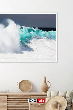 a living room with a couch, chair and large wave crashing on the ocean wall