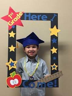 a young boy wearing a graduation cap and holding a guitar in front of his face