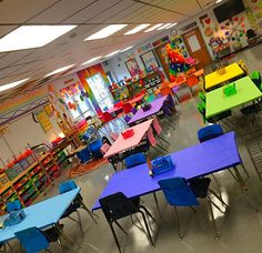 an empty classroom with colorful tables and chairs