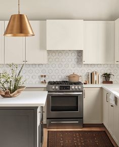 a kitchen with an oven, stove and counter tops in white cabinetry next to a sink