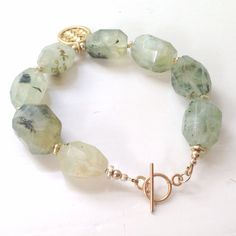 This green prehnite bracelet created by Jewelry By Carmal is made of green natural prehnite nugget gemstones, 24K gold vermeil: spacers, woven disk charm (approximately the size of a nickel), toggle closure and findings. The bracelet measures 9 1/2 inches in length. View more beaded bracelets: http://www.etsy.com/shop/jewelrybycarmal?section_id=8002918 All of our jewelry arrives wrapped and ready for gift giving! We offer free shipping via USPS within the United States! Green Natural Stones Bracelet For Everyday, Nature-inspired Green Bracelets With Natural Stones, Green Amethyst Jewelry With Natural Stones, Handmade Green Prehnite Jewelry, Spiritual Healing Jewelry Made Of Prehnite, Hand-strung Green Nature-inspired Jewelry, Green Gemstone Bracelets For Everyday Wear, Green Faceted Spiritual Bracelets, Adjustable Green Moss Agate Bracelet