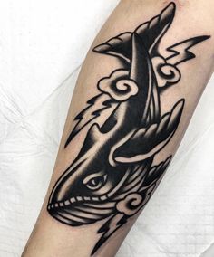 a black and white tattoo on the arm of a man with an orca whale