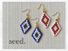 three beaded earrings with the words seed written on it and two small beads hanging from them