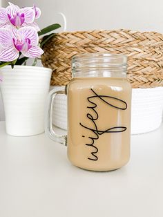 there is a glass jar with the word hope on it next to a basket and flowers