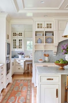 a kitchen filled with lots of white cabinets and counter tops