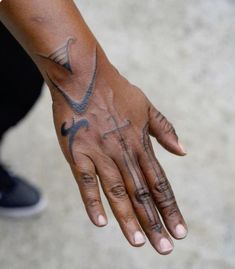 a person's hand with tattoos on it and an arrow tattoo on the palm