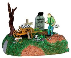 a figurine of a man with a wheelbarrow in front of a grave