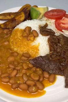 a white plate topped with beans, rice and meat