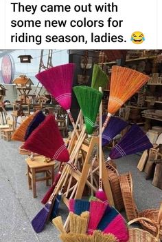 many colorful umbrellas are on display in front of chairs and other items at an outdoor market