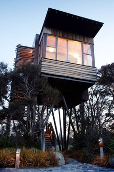 the house is built on stilts and has windows that look out onto the water