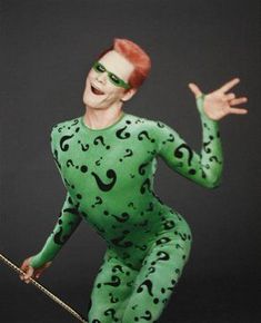 a man in a green bodysuit with black numbers on his face and hands out