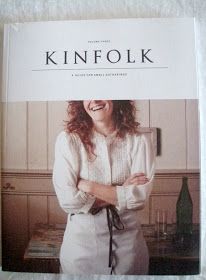 a woman standing in front of a kitchen counter with her arms crossed and looking at the camera