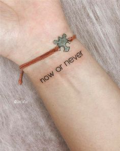 a wrist tattoo with the words now or never written on it and a small turtle