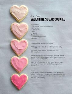 four heart shaped sugar cookies sitting on top of a sheet of paper