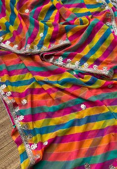 Add a splash of color to your wardrobe with our Multicolor Leheriya Saree, perfect for festive occasions. Crafted from soft georgette fabric, this saree features vibrant leheriya patterns complemented by intricate Gota Patti handwork, adding a touch of traditional elegance. Paired with a matching blouse made from the same georgette fabric, this ensemble is a celebration of vibrant hues and exquisite craftsmanship. Fabric: Georgette Work: Handwork of Gota Patti Care: Dry Clean Only *Product color Bridesmaids Saree, Leheriya Saree, Bridesmaid Saree, Gotta Patti, Lehenga Wedding, Wedding Lehenga, Georgette Saree, Work Sarees, Georgette Fabric