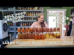 a woman standing in front of jars filled with food