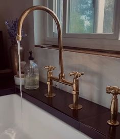 a sink with two faucets on it and a window in the back ground