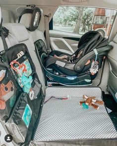 an infant car seat in the back of a vehicle with various items on it's tray