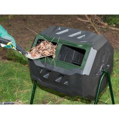 a person in green gloves is removing leaves out of a black and gray television set