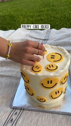 a woman is cutting into a cake with smiley faces on it