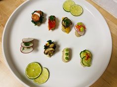 a white plate topped with lots of different types of sushi and cucumbers