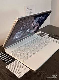 an open laptop computer sitting on top of a wooden table