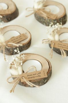 four pieces of wood are tied with twine and labeled with wedding names on them