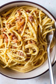 a bowl filled with pasta and topped with bacon