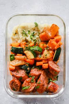 a glass container filled with vegetables and meat