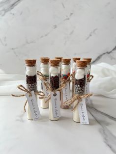 four small bottles filled with sand and spices