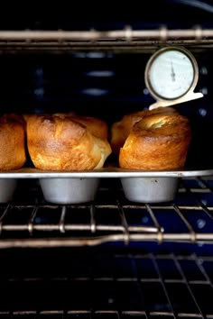 three muffins sitting in an oven with a thermometer